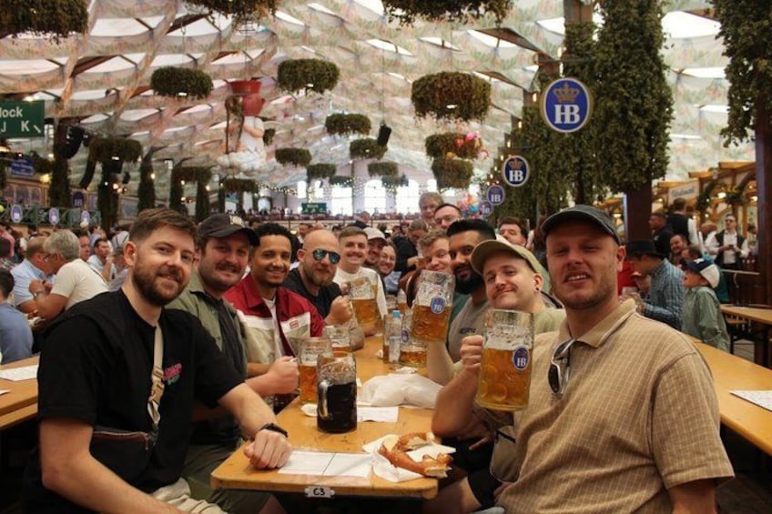 A group of people at a beer festival, holding large beer mugs. 3