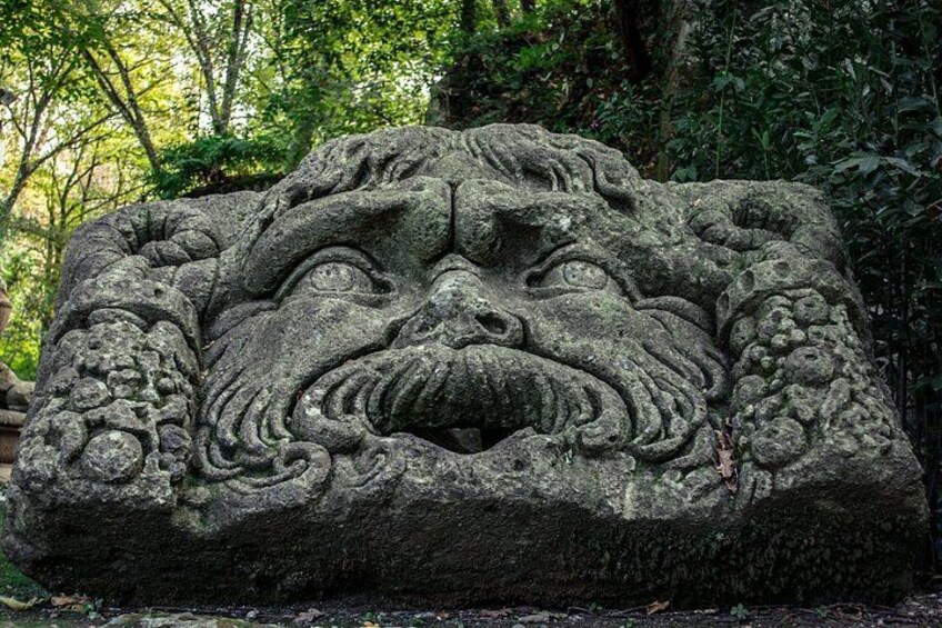 A stone carving of a mythical creature's face with intricate details. 2