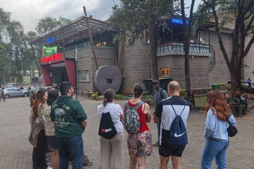 Un groupe de personnes se tient devant un bâtiment sur lequel on peut lire l’inscription « HÔTEL ». 2