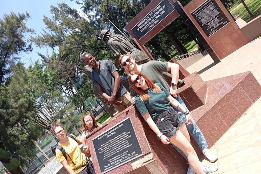 Un gruppo di persone che posa davanti a un monumento con iscrizioni. 3