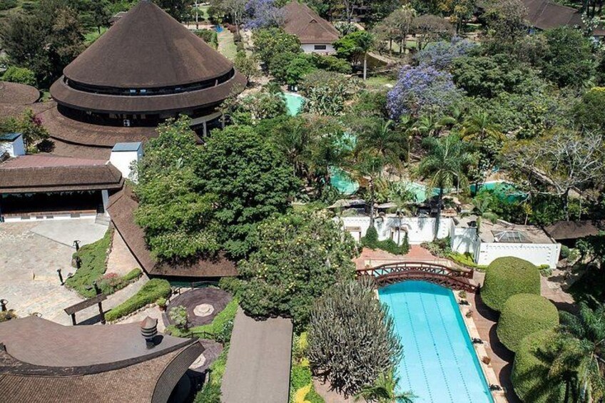 A resort with a swimming pool, a bridge, and a large tree. 3