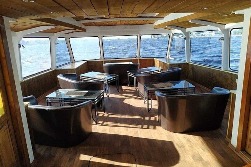 L'intérieur d'un bateau, avec des sièges et des tables, de grandes fenêtres et un plafond en bois. 5