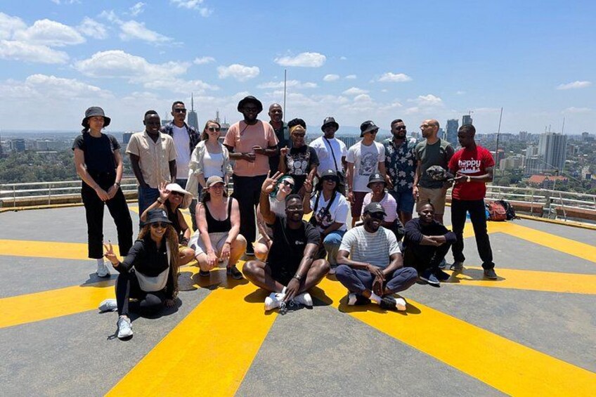 A group of people posing on a rooftop with a cityscape in the background. 5