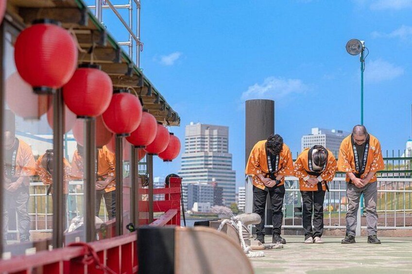 Werkers in oranje uniformen op een dak, rode lantaarns en een stadsachtergrond. 3