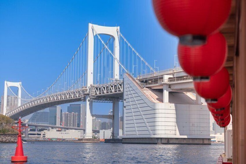 A large suspension bridge with two towers, a river, and a red buoy. 3
