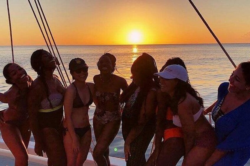 Eine Gruppe von Menschen auf einem Boot bei Sonnenuntergang. 5