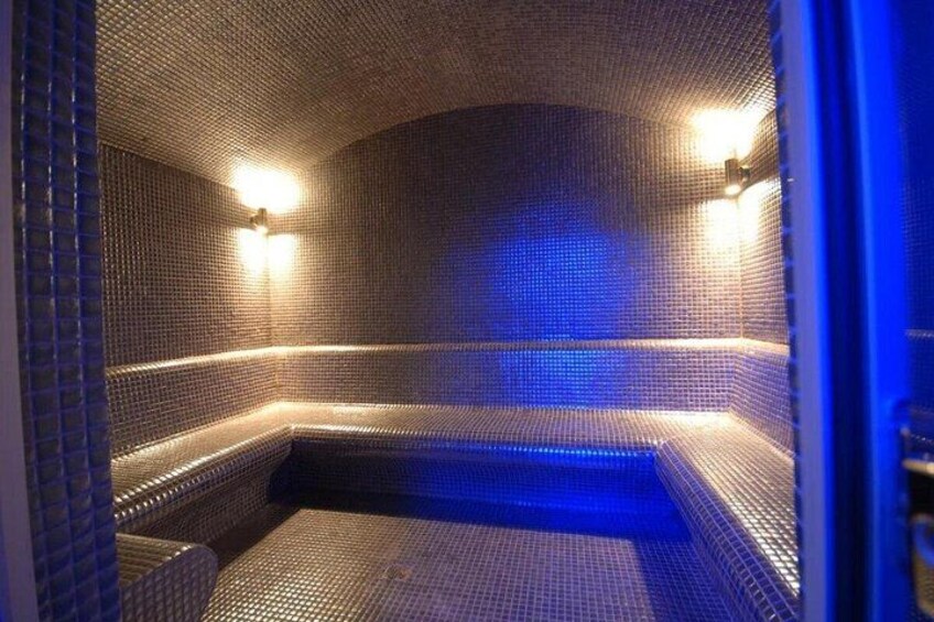 Een hottub met betegelde wanden en blauwe verlichting. 2
