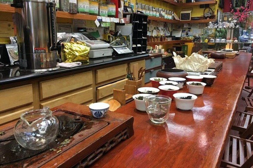 A bar with a wooden counter, various containers, and a coffee machine. 3