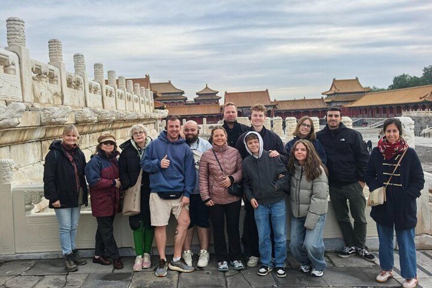 A group of people posing in front of ancient ruins with traditional architecture in the background. 4