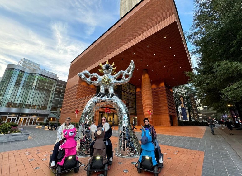 A building with a large, ornate archway and three people on scooters in front. 2