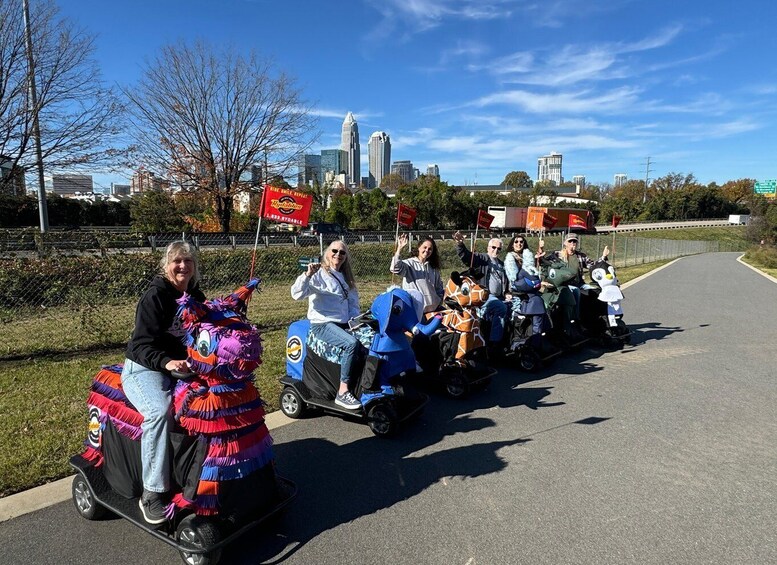 People on small vehicles with colorful decorations, a city skyline in the background, and a clear sky. 4