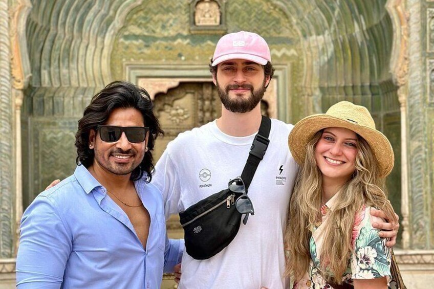 Three people in front of a historic building with intricate carvings. 3