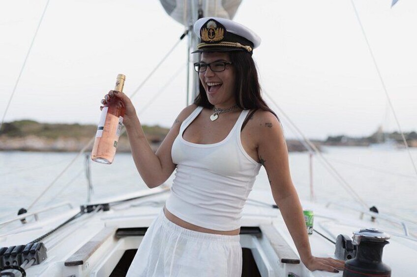 Una persona en un velero sosteniendo una botella de champán. 4