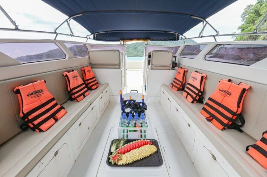 A boat interior with life jackets on the seats, a cleaning brush, and bottled water. 2