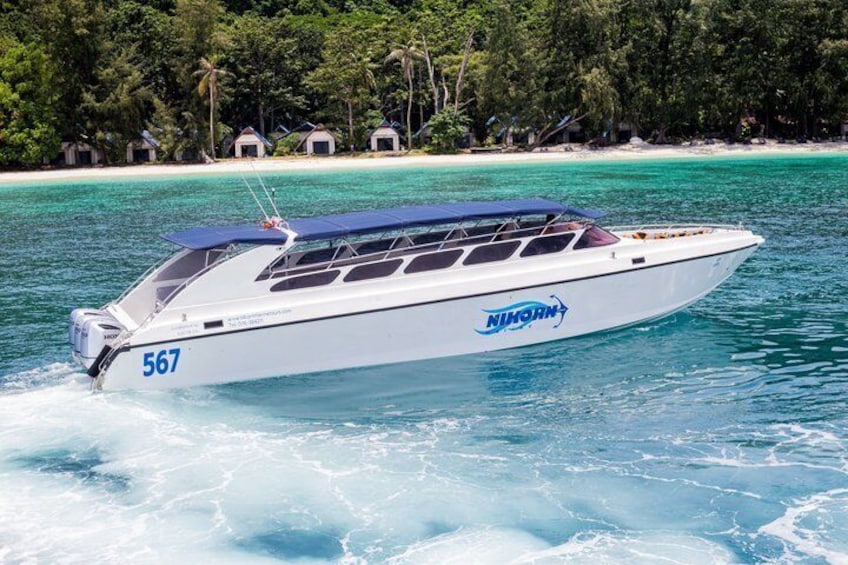 A speedboat with the number 567 on the bow, moving through turquoise waters with a backdrop of a tropical beach and dense greenery. 3