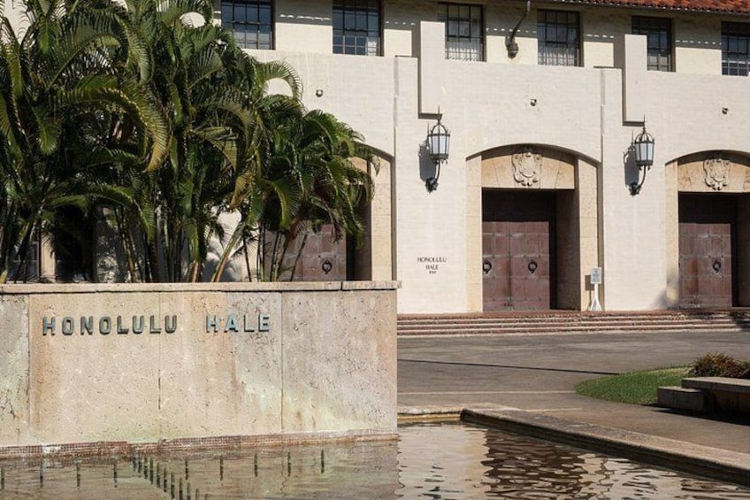 En bygning med skiltet 'HONOLULU HALE' og et vandelement foran. 1