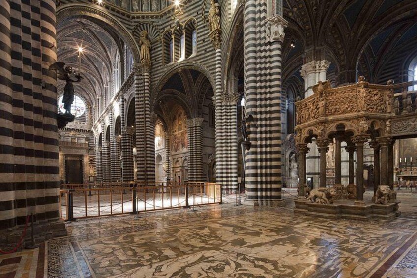 L’intérieur d’une cathédrale, avec ses colonnes rayées, ses voûtes en arc et ses sculptures complexes en pierre. 5