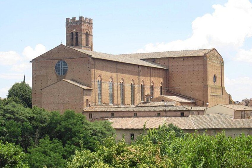 Une grande église en briques, dotée d’un clocher, de fenêtres en arc de cercle et d’un toit recouvert de tuiles. 4