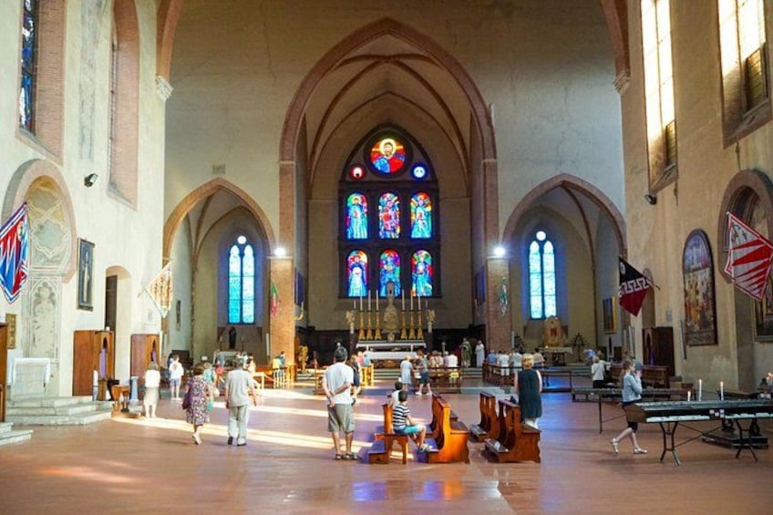L’intérieur d’une église avec des vitraux, des bancs et un baptistère. 2
