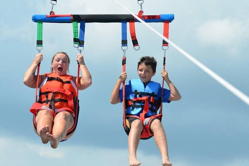 Two individuals on a swing set suspended in the air. 2