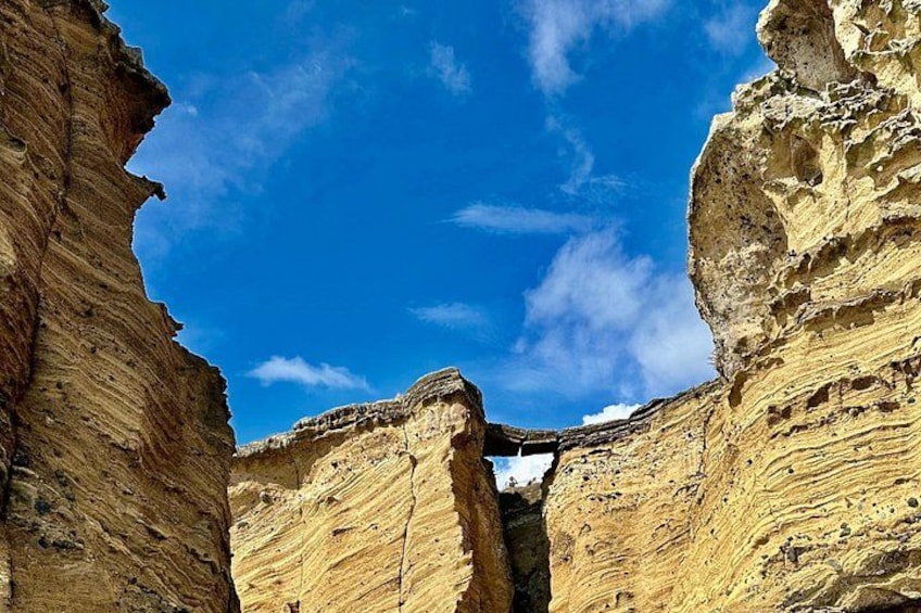 A canyon with layered rock formations and a clear blue sky. 3