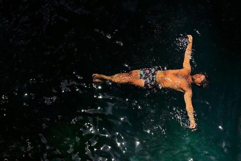 Une personne flottant sur l’eau, les bras tendus. 3