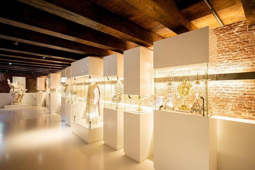 A museum interior with glass display cases containing various artifacts. 3