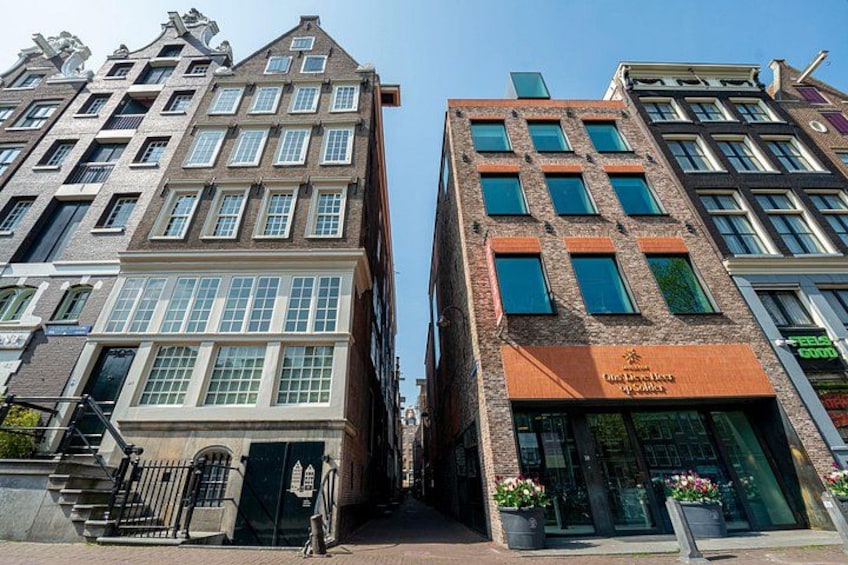 A street with historic buildings, a shop with a sign, and a clear sky. 2