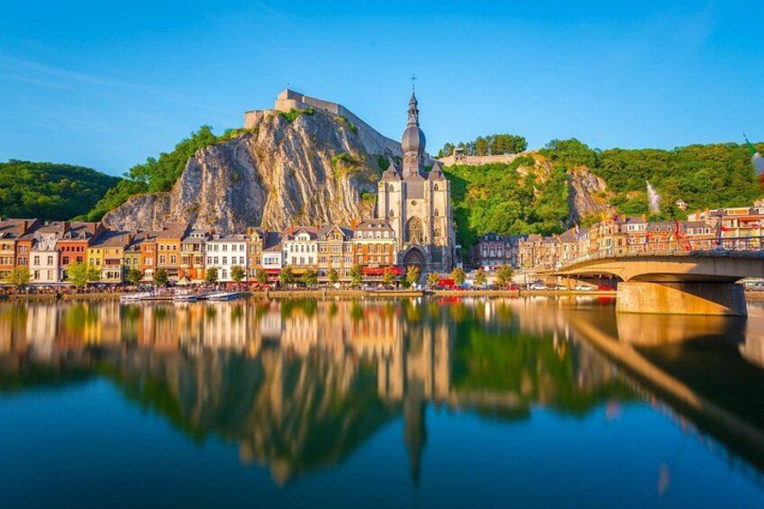 A river reflecting a historic church and a castle on a hill. 5