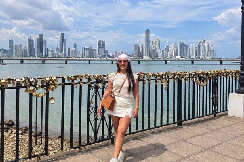 A person standing by a waterfront with a city skyline in the background. 5