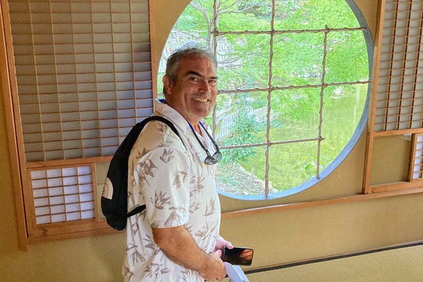 A person standing indoors with a window in the background. 3