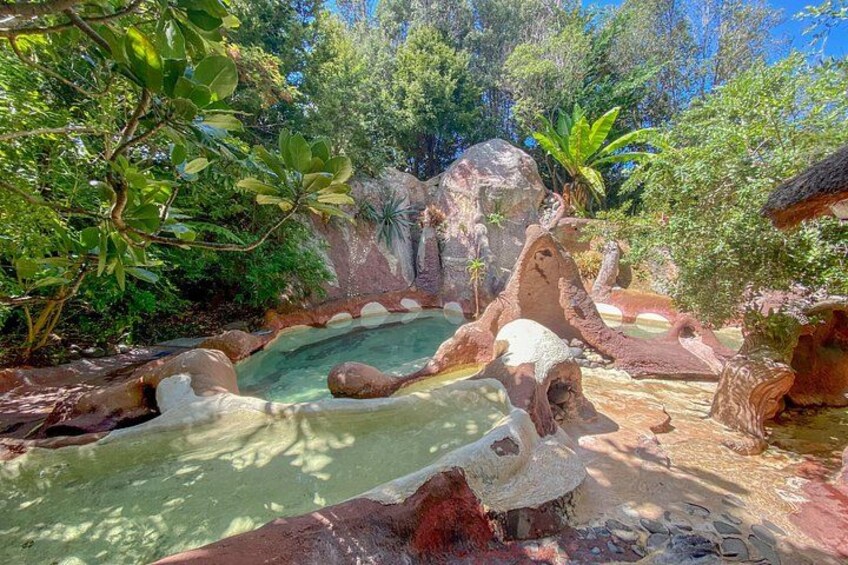 A natural landscape with a pond, rocks, and trees. 5