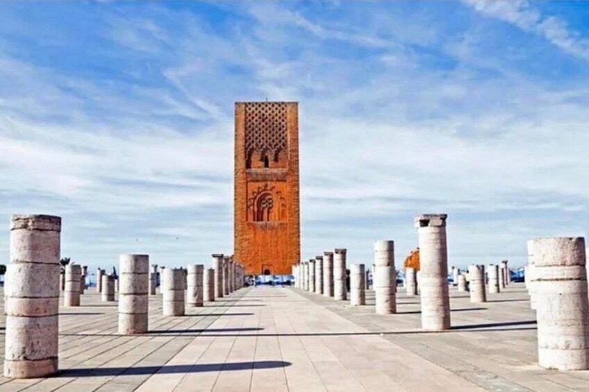Ein historischer Turm mit aufwendigen Schnitzereien, umgeben von gleichmäßig verteilten Säulen. 3