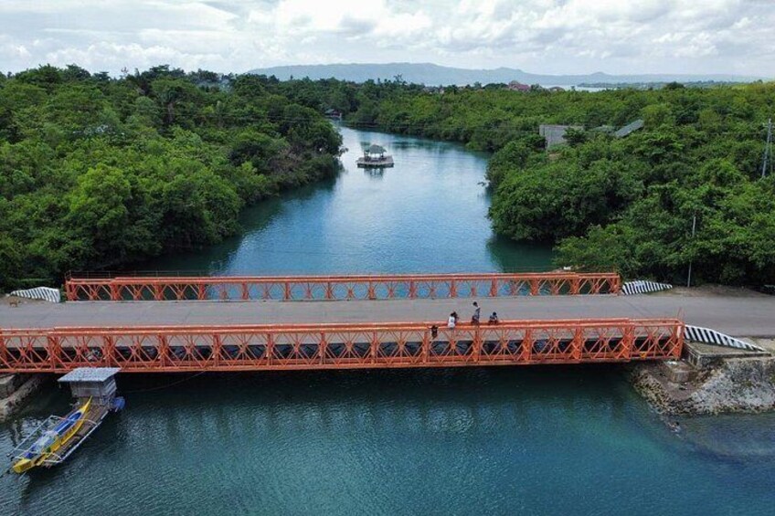 A red bridge over a river surrounded by dense greenery. 5