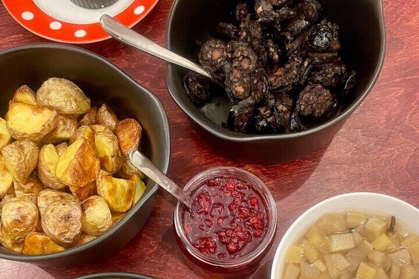 A table with various dishes including roasted potatoes, a bowl of blackberries, and a bowl of apple slices. 5