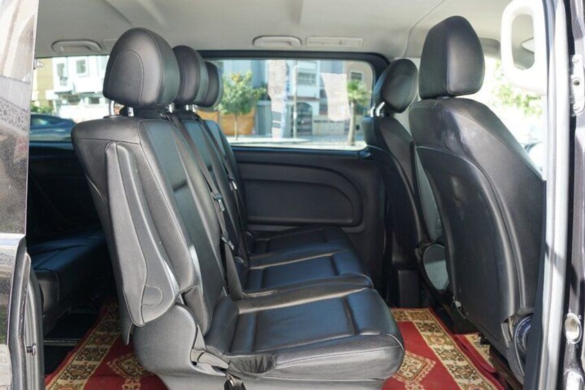 Ein Auto Innenraum mit schwarzen Ledersitzen und einem roten Teppich. 2