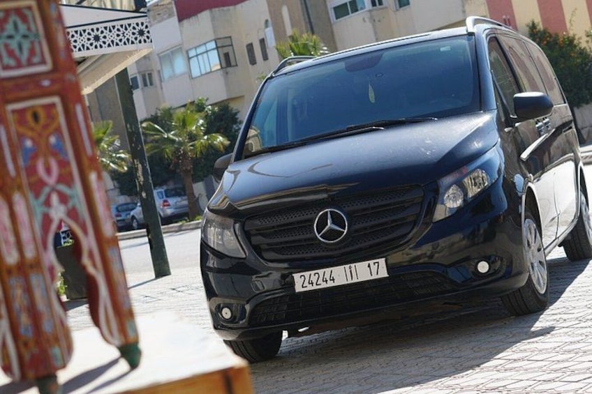 Un SUV Mercedes-Benz negro estacionado en una calle adoquinada con edificios al fondo. 5