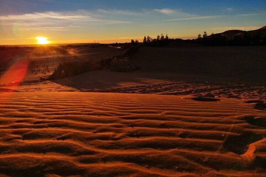 A desert landscape with sand dunes and a sunset. 2