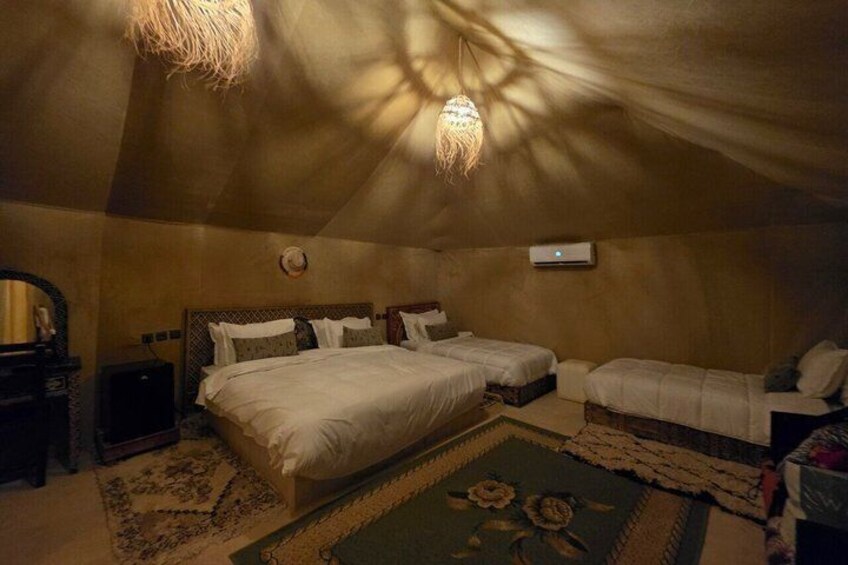 A cozy, dimly lit bedroom with a large bed, two smaller beds, a dresser, and a mirror. 4