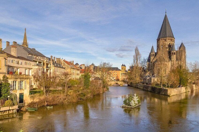 Un río con un castillo, un puente y edificios a lo largo de la orilla. 1