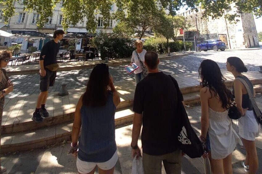 Un grupo de personas caminando por una calle empedrada, con árboles y edificios al fondo. 2