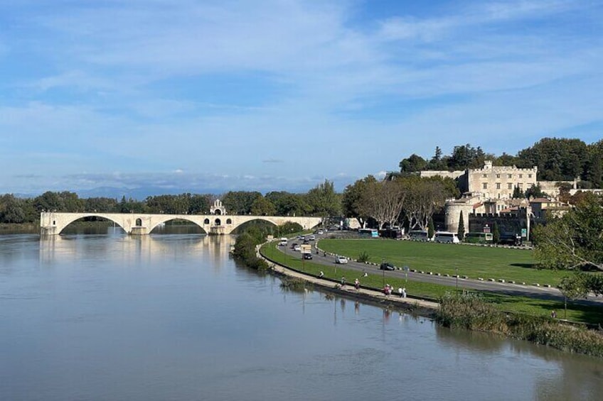 Un puente de piedra sobre un río, un castillo y un parque con una carretera. 3