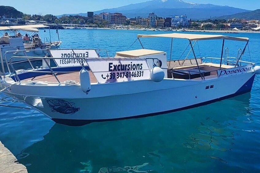 A boat docked at a marina with a clear blue sky and mountains in the background. 1