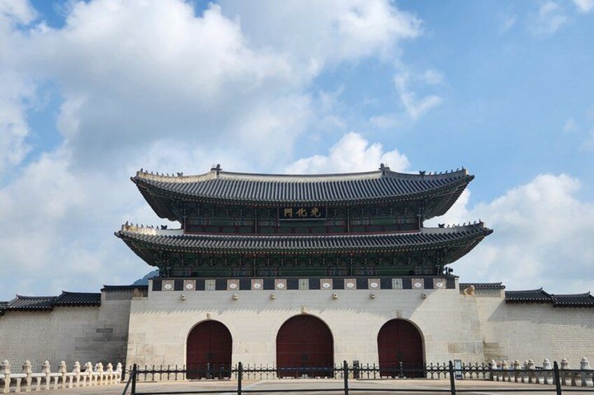 A traditional Korean gate with a multi-tiered roof and two large arched entrances. 3
