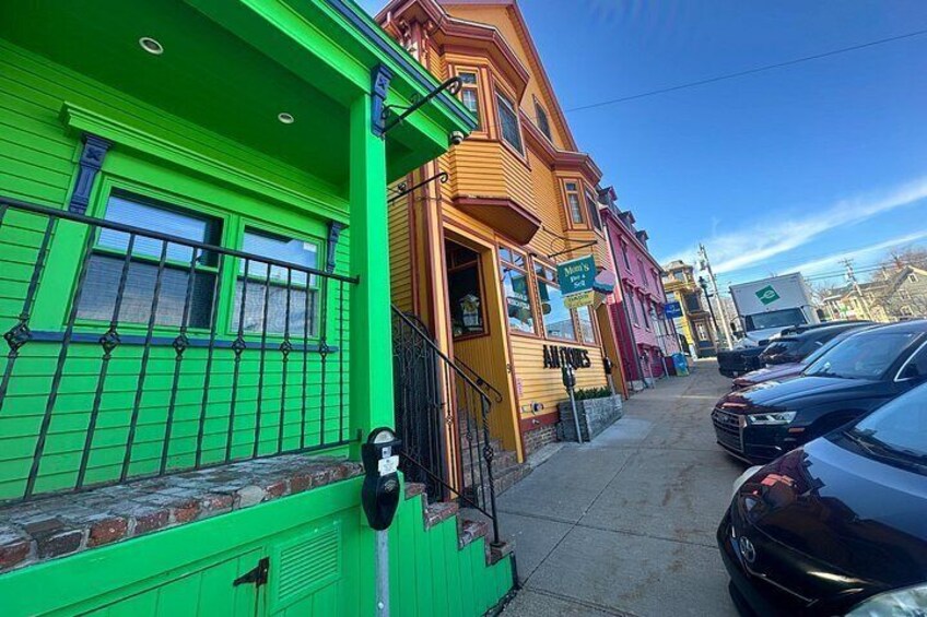 A street with colorful buildings, a parking lot, and a clear sky. 3