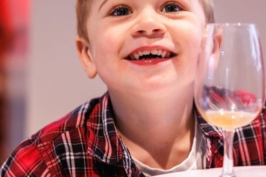 A person wearing a plaid shirt with a glass of a light-colored beverage. 2