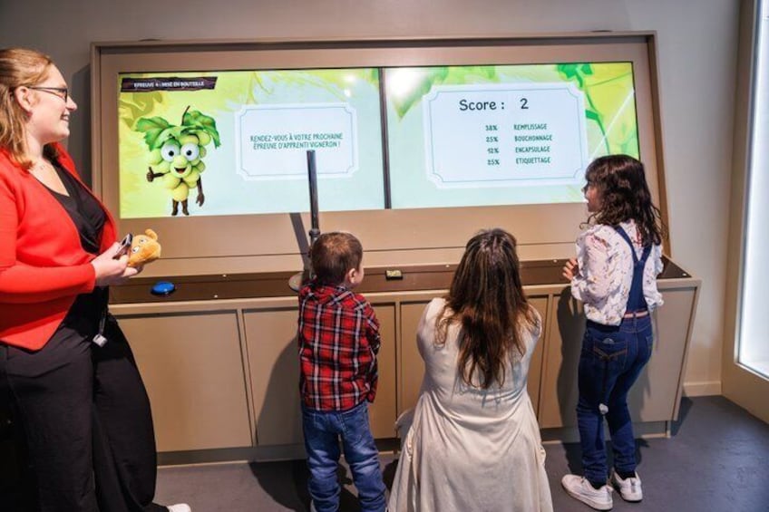 A woman presenting to children at a kiosk with a digital display. 3