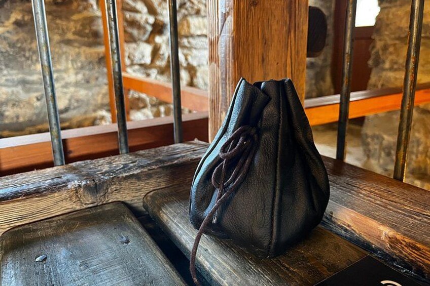 A black bag on a wooden bench with metal bars in the background. 2