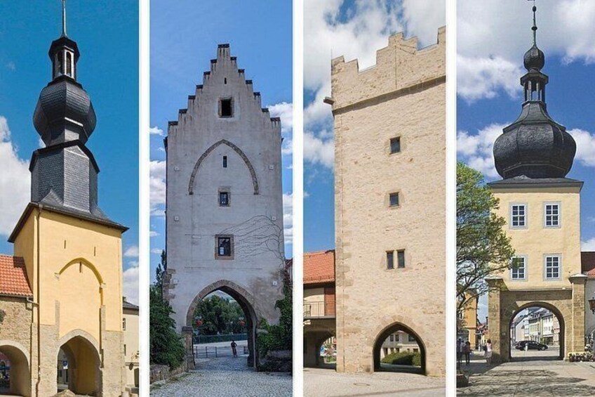 Una iglesia con un campanario, una puerta medieval fortificada, una torre de piedra alta y un edificio con cúpula. 1