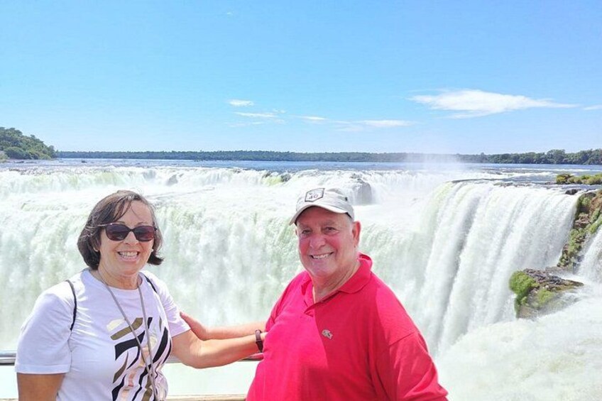 Two people standing in front of a waterfall. 2